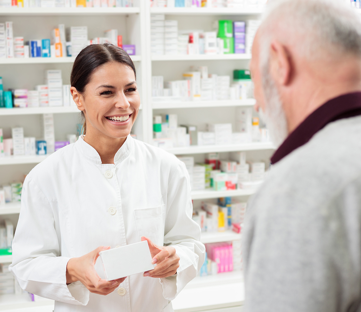 Pharmacist holding medicine and smiling at customer